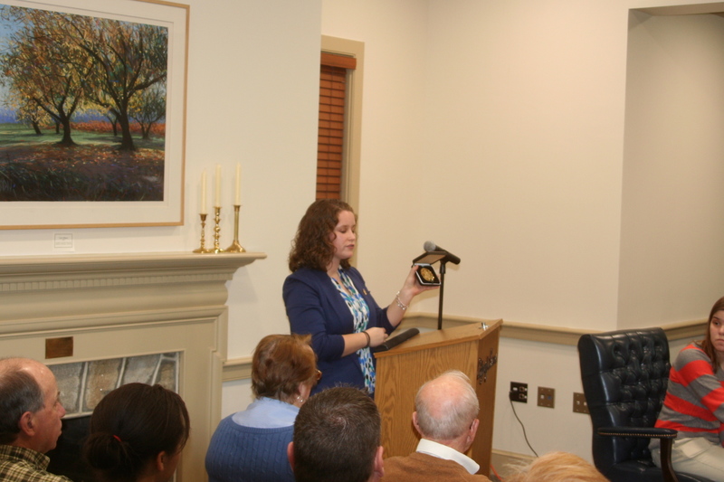 Alison Wade displays a Jefferson Awards Gold Medallion and tells the public about the program at Lewes Mayor and City Council's meeting last month. A medallion will be awarded to the top three projects submitted to the City of Lewes' Youth Service Challenge. Wade is a University of Delaware senior who is working as an intern with the Jefferson Awards program. BY HENRY J. EVANS JR.